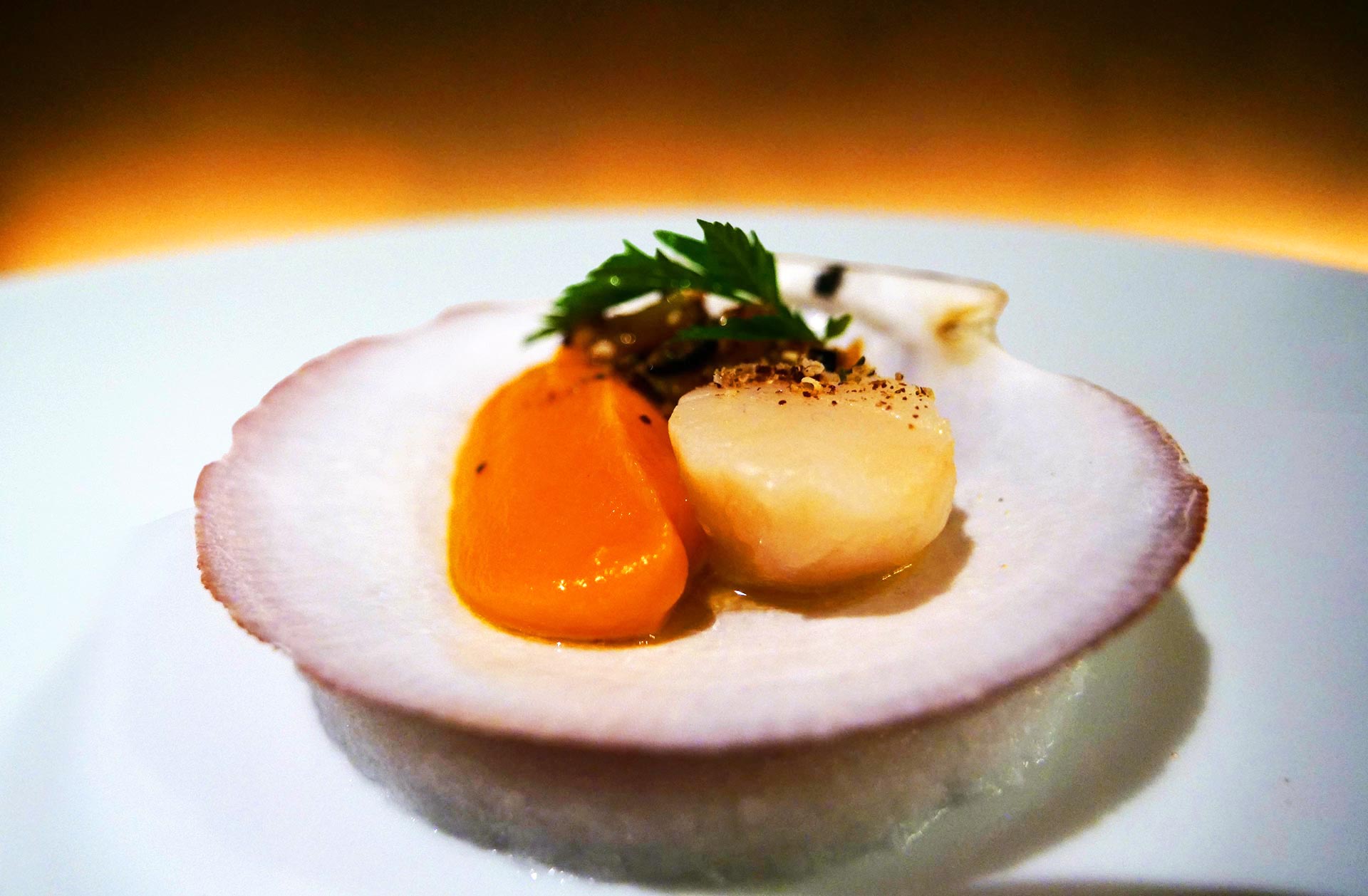 Scallop with orange, black olives and sumac at restaurant LUMI in Old Montreal