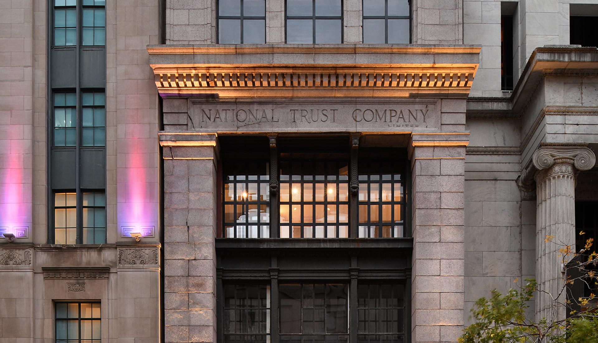 Neo Classical building Façade of SonoLux Hotel in Old Montreal with original engraving National Trust Company
