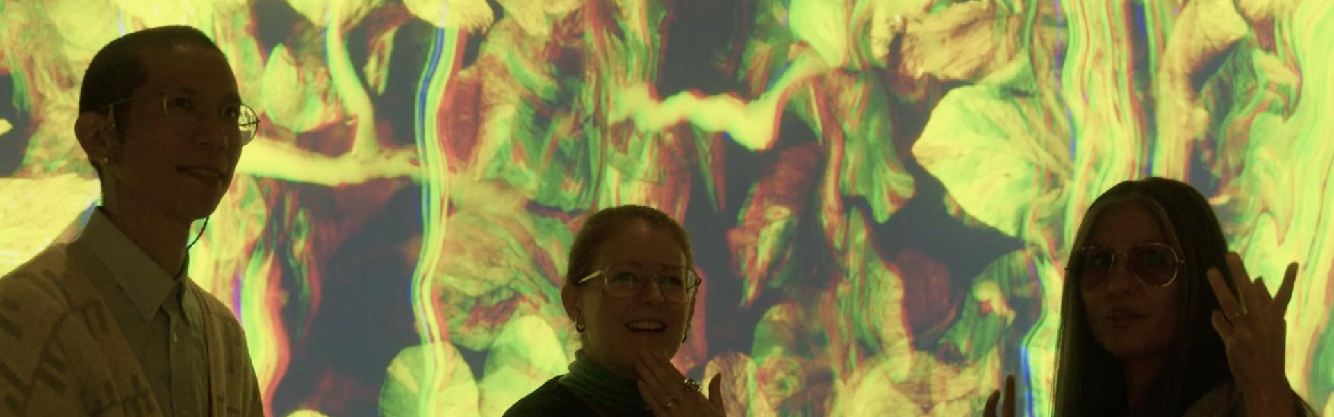 Léon Lo, Katherine Melançon et Cheryl Sim dans le lobby de SonoLux avec l'oeuvre Pour amortir la chute en arrière-plan