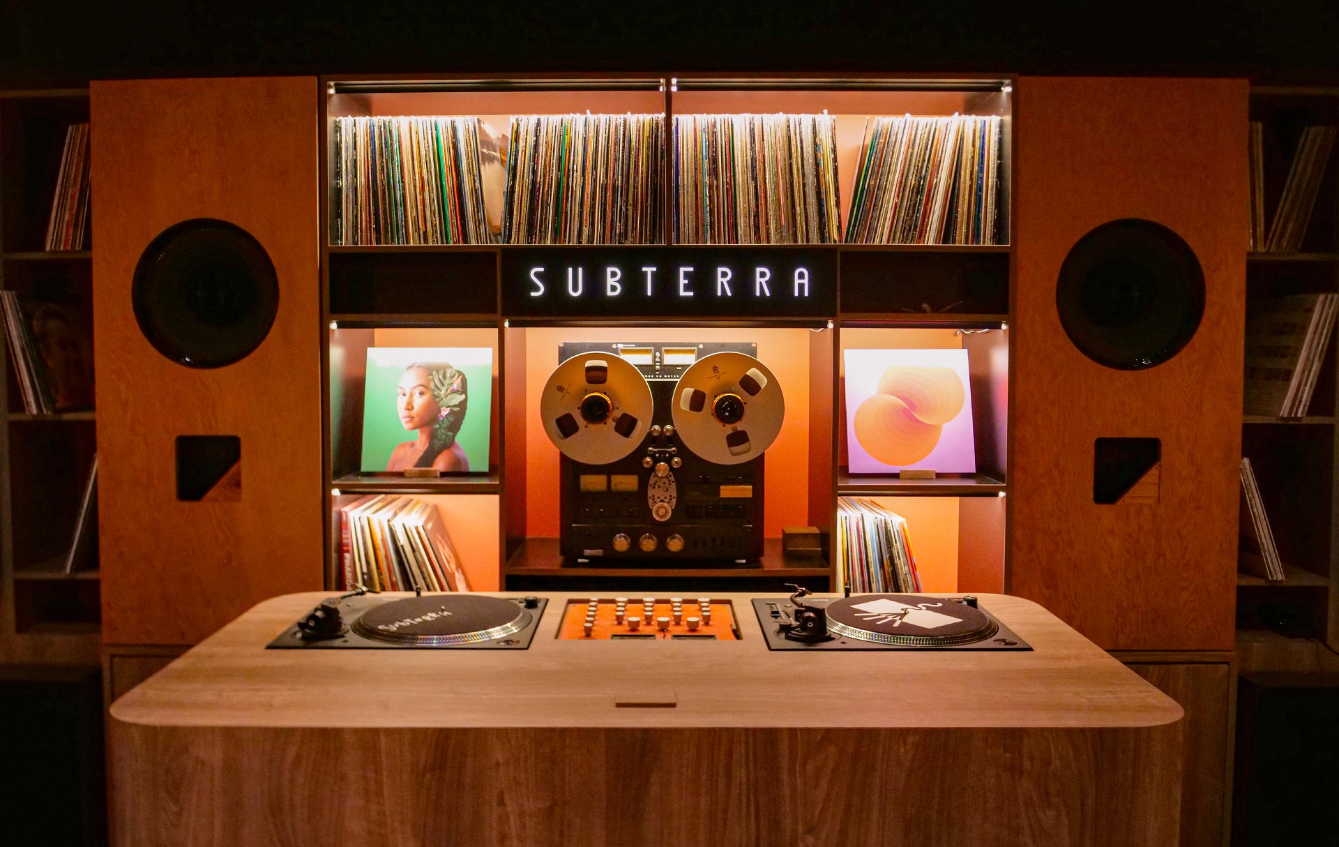 Subterra audio wall with vinyls, reel to reel, large Altech speakers and vinyl DJ booth.